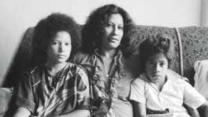 Merata Mita sits with two her children in a black and white portrait.