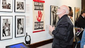 AIDS Library co-founder John Cunningham takes in the art and messages at 'Still Fighting for Our Lives.' (Photo by Holly Clark)