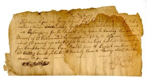A yellowed fragment of 18th-century paper has 8 lines of fine ink cursive and a flourishing signature.