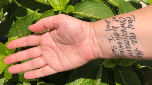 Tattoo on the underside of Alaina's wrist. Black handwritten text reads “Pay me the compliment of believing what I say"