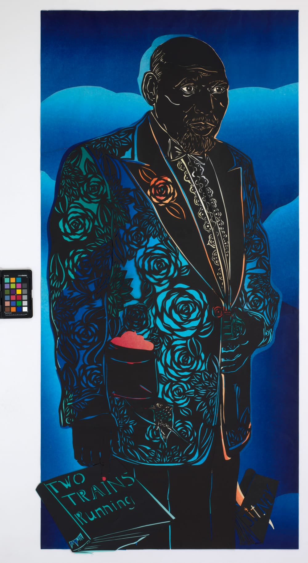 August Wilson's portrait described in the piece. Shades of blue, teal, & flashes of yellow & orange break through the black.