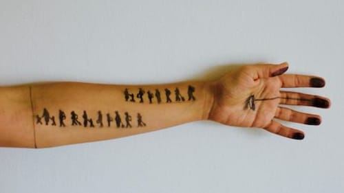 Refugee Basel Zaraa draws images of displacement on visitors' arms. (Photo courtesy of the artist.)