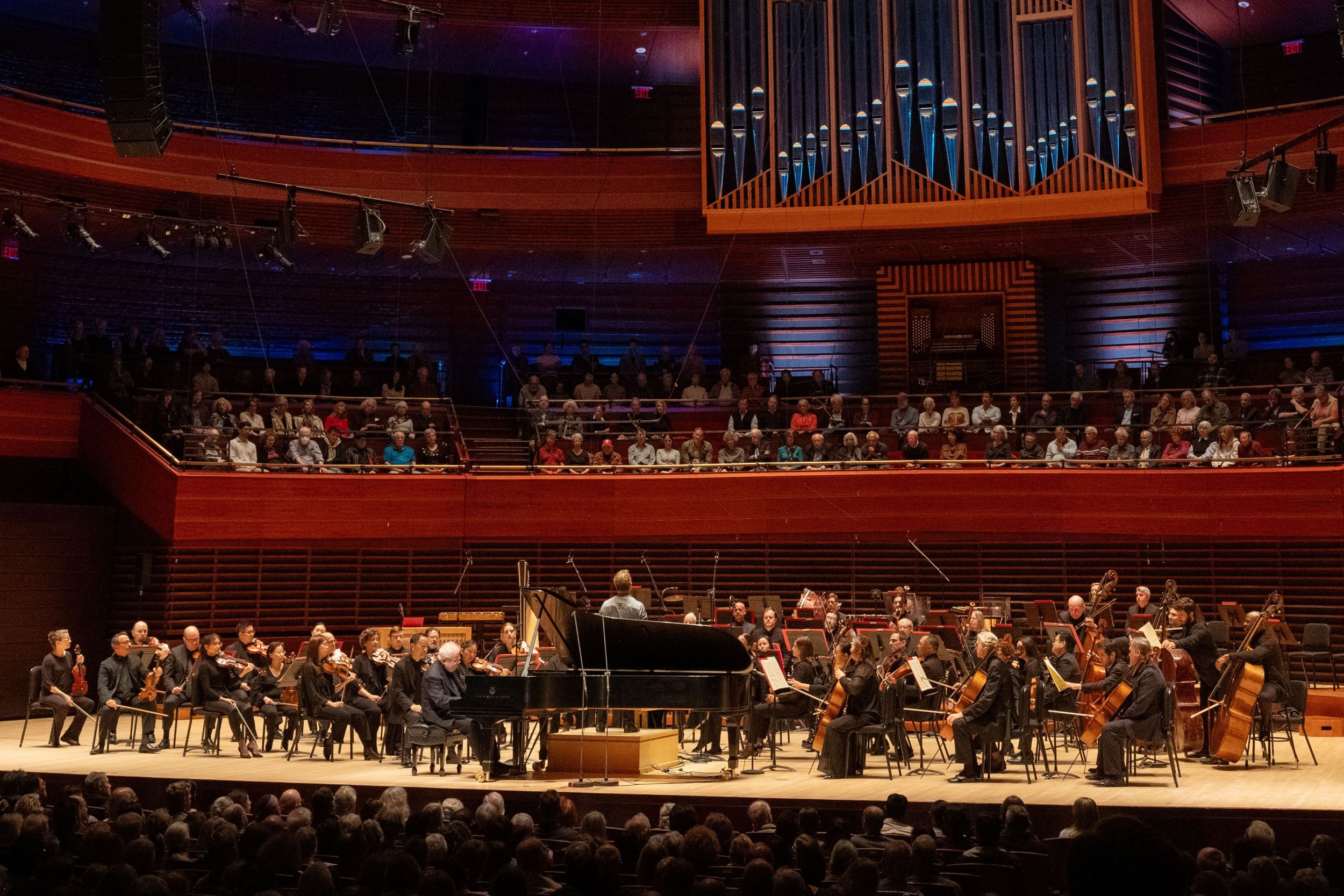 Full view of Marian Anderson Hall stage, with the whole orchestra, Nézet-Séguin conducting, Ax playing a grand piano at front