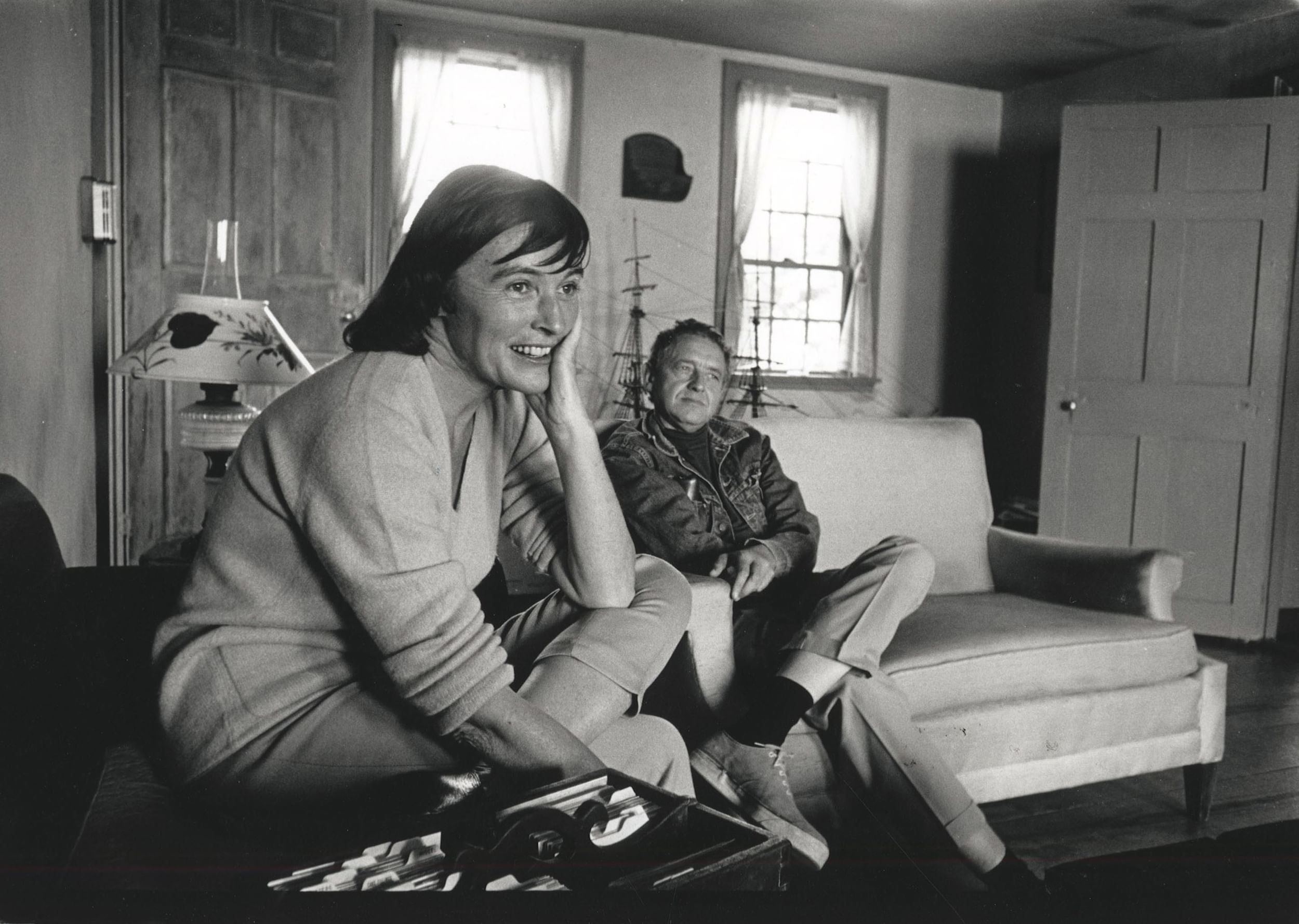 Black & white photo of the Wyeths sitting comfortably together in a rustic living room with seafaring touches.