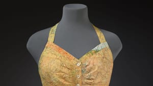 On a torso mannequin, a two-piece halter-and-shorts swimsuit made from a vintage WWII pilot’s map.