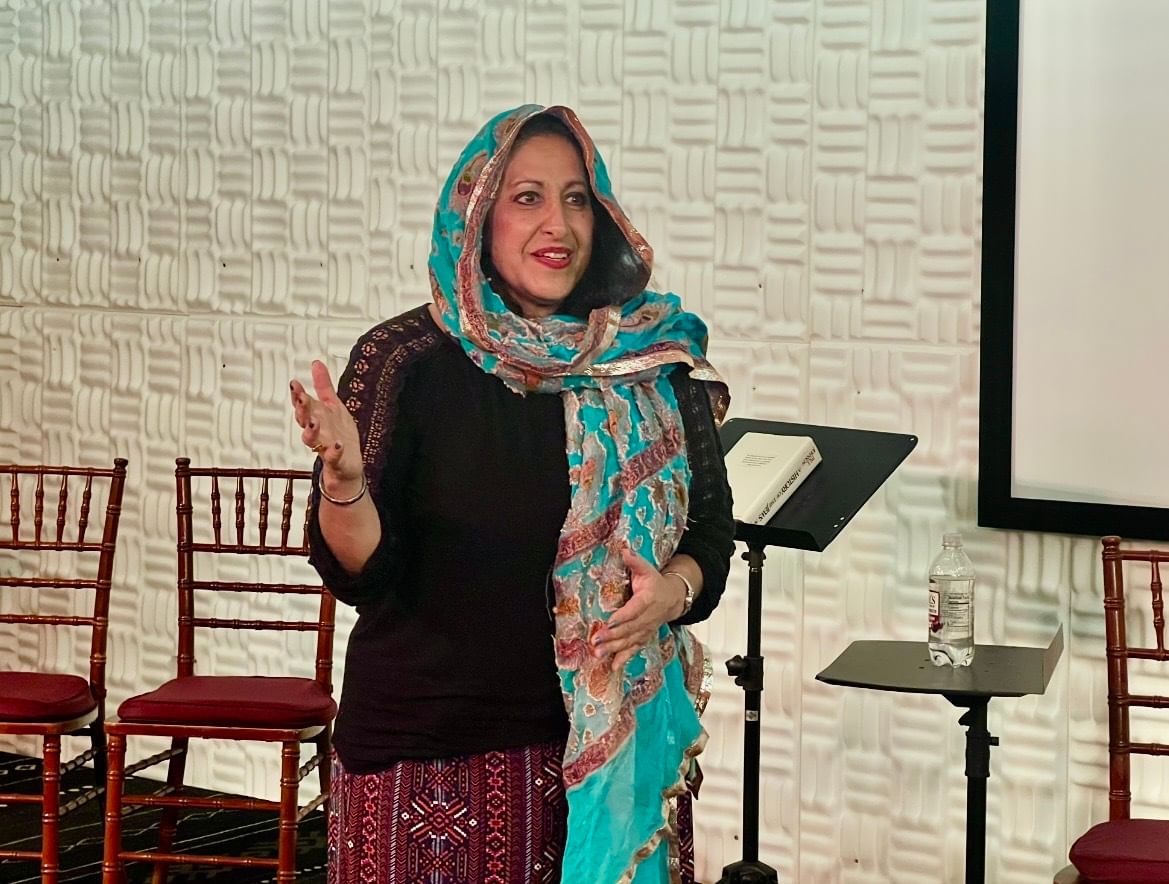 David, a Jewish woman of Iraqi heritage, performs wearing a flowing, ornate turquoise and gold headscarf.