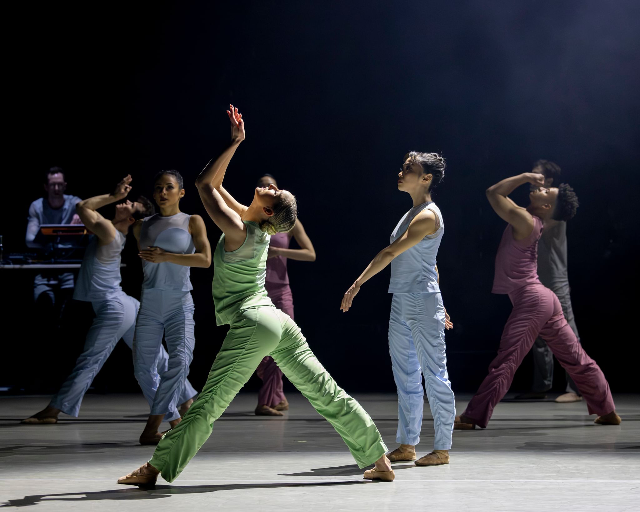 Lubin & ensemble strike different poses in solid pastel pants & tanks with ruching. Ordway performs electronic music at left