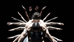 Several dancers stand behind Forcella, bowed at the waist, and all you can see are their arms spreading like a peacock tail