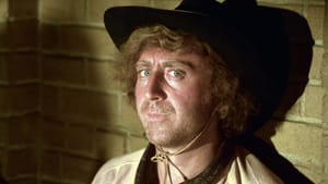 Film still, Gene Wilder in character, dressed up as a cowboy, looks directly at camera, leaning against a brick wall