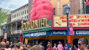 Outside a movie theater, a large, inflated ‘blob’ stands behind the ‘Colonial’ theater sign. A crowd is outside the theater