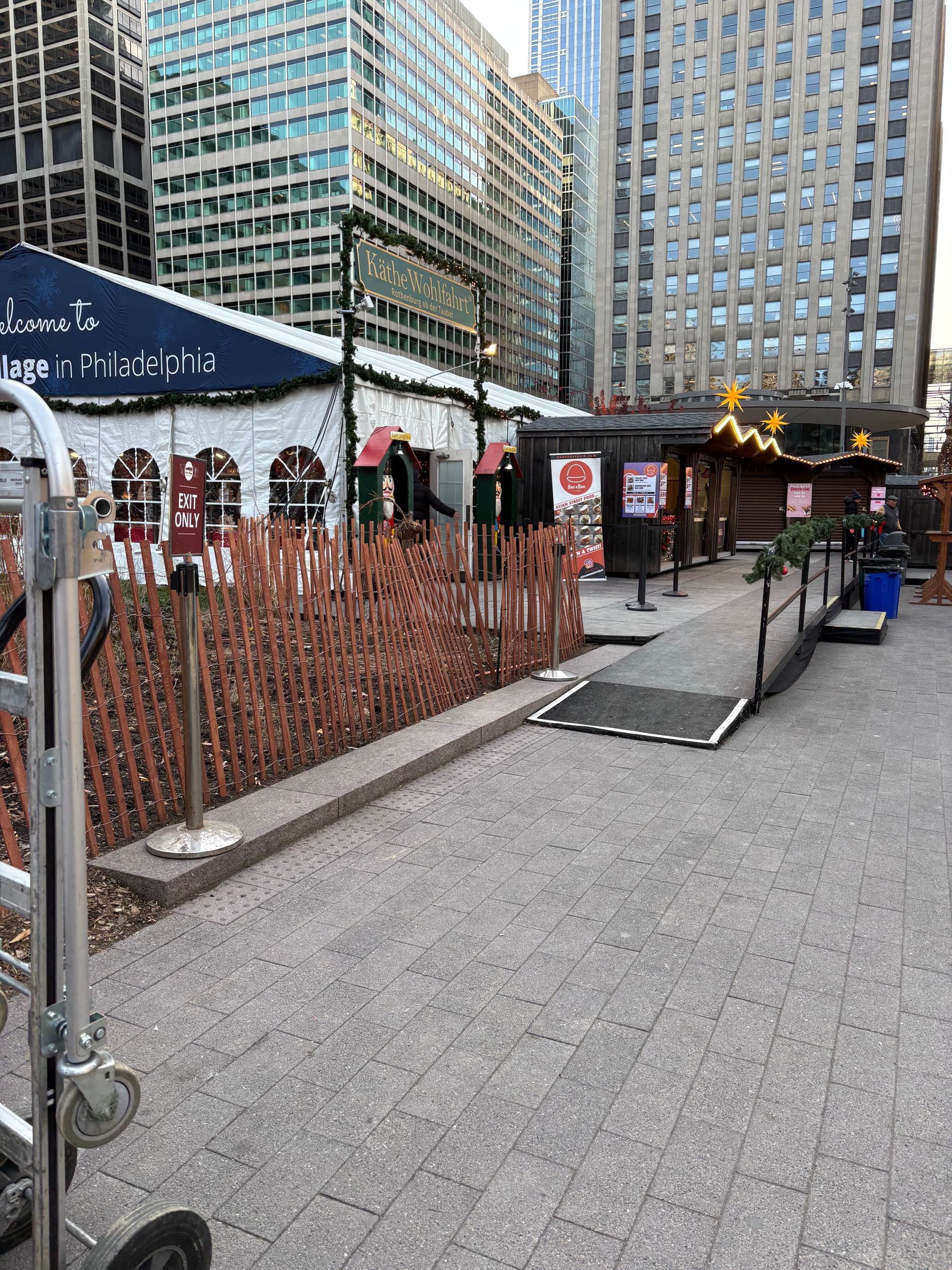 Daytime photo of a small ramp from one area of the village to another. It is narrow and lacks signage.