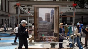 Installation view on a sunny day outdoors, focused on a life-sized photo of the view from a City Hall window.