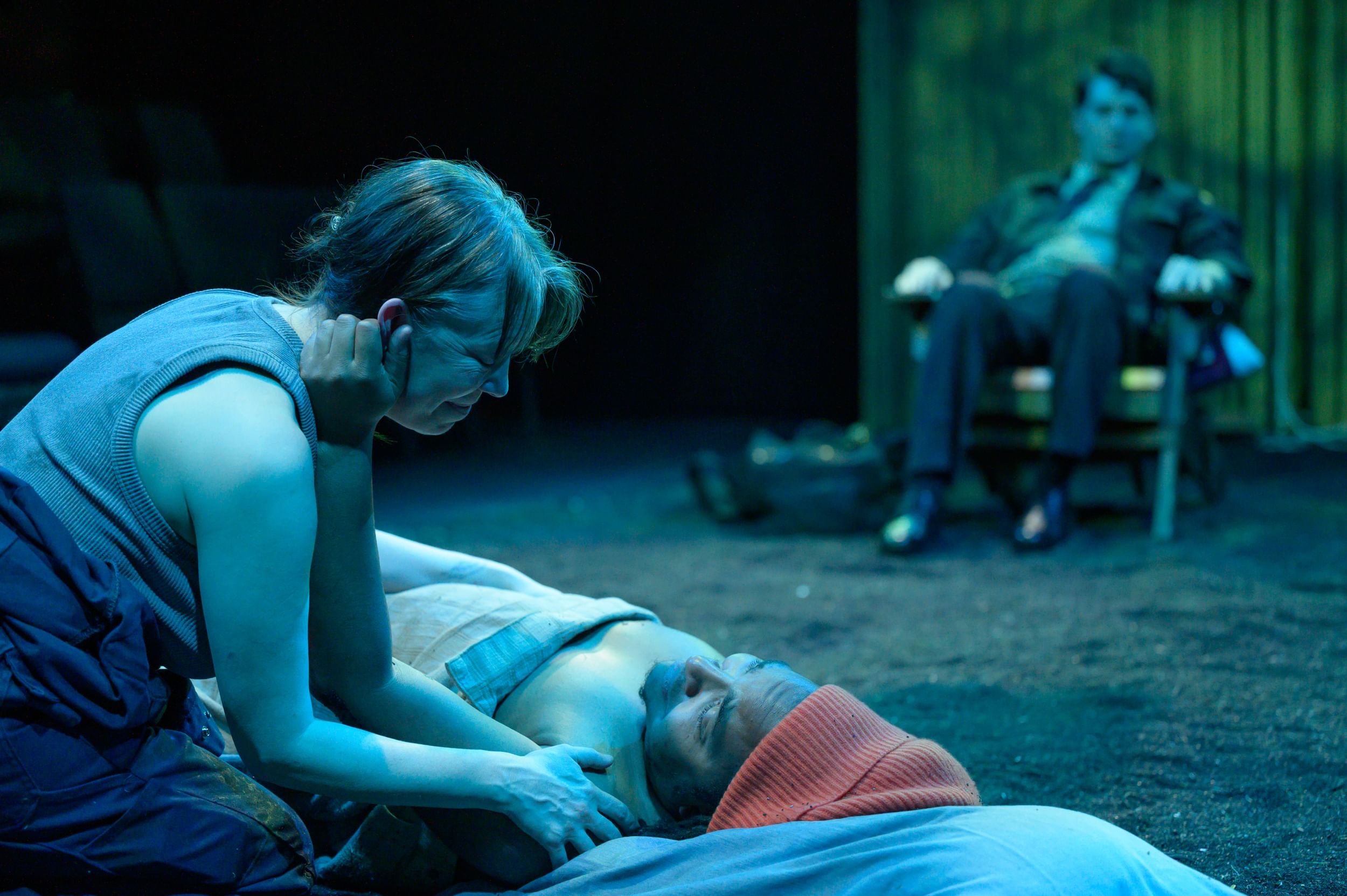 In deeply emotional posture, Schoonover leans over Espinoza lying on the ground, touching his shoulder. He touches her face