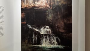 A detail of the painting, showing a waterfall coming from a dark cave, is reproduced in large scale right on the gallery wall