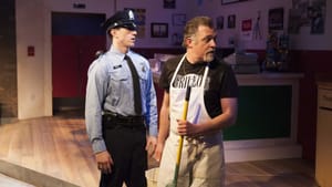 Friendly cop Stanley (Brian Cowden) tries to defuse the tensions caused by Nicky's (William Zielinski) anti-immigrant actions.