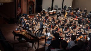 A view from above of the full DSO playing on a wooden stage, with the pianist out front.