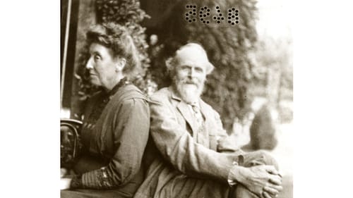 Black & white photo of the elderly De Morgans, sitting casually back-to-back on an outdoor wrought-iron bench.