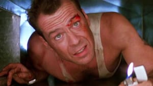 Film still with actor Bruce Willis close to the camera in a ventilation duct, a lighter close to the edge of the frame