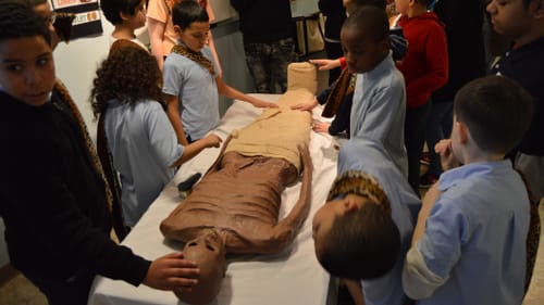 Students from an Autistic Support class at H.A. Brown inspect a papier-mache desiccated mummy in the Penn Museum's Mummy Makers workshop. (Photo by Emily Hirshorn)