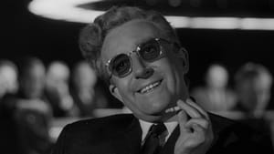 Movie still of Strangelove, in a suit, tinted glasses, a cigarette, head tilted w/ a smile, people out of focus behind him