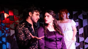 Carter, in a sexy black lace shirt, speaks to Silano, who wears a satiny purple dress and looks perturbed.