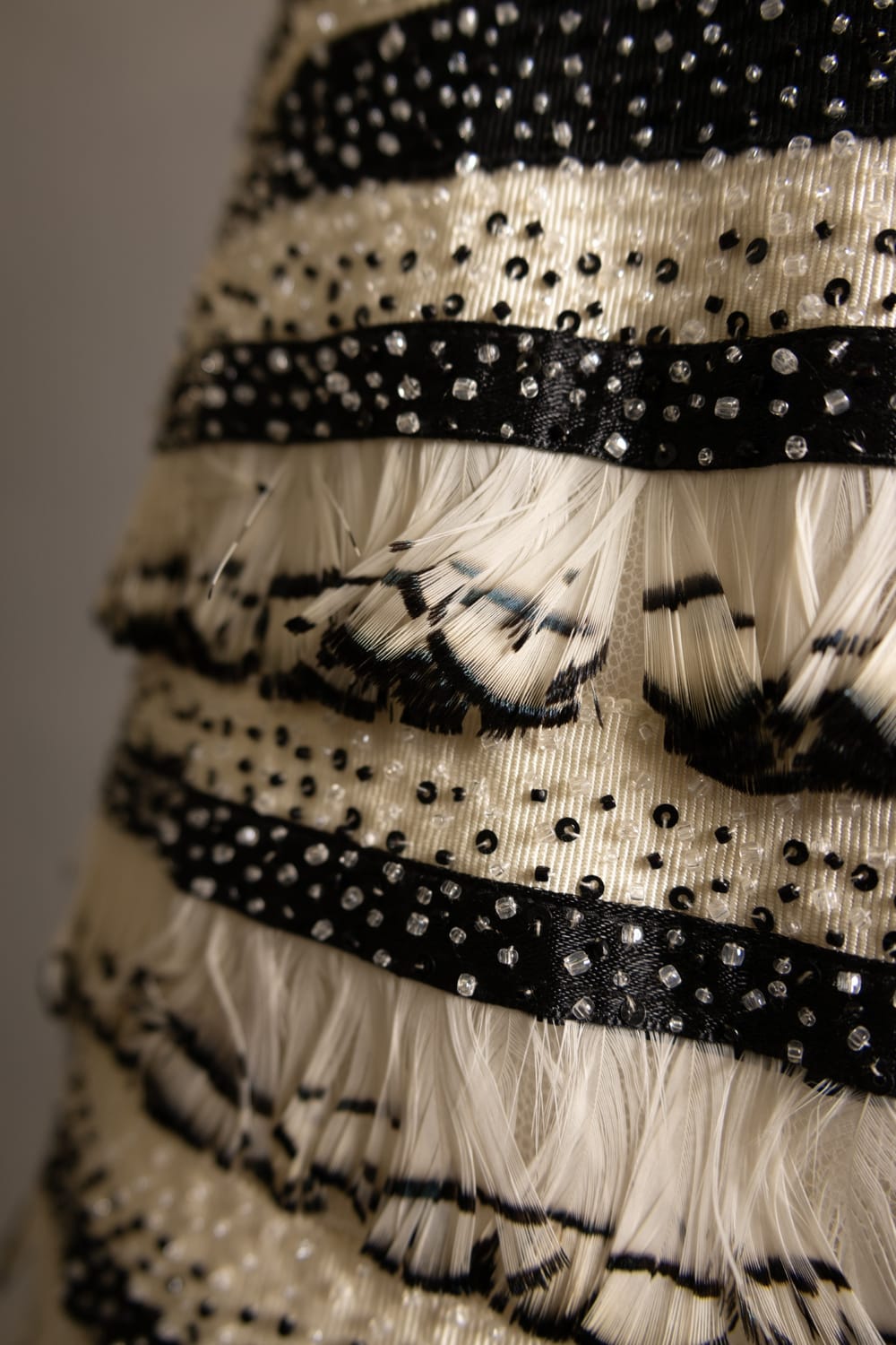 Silk, rayon, glass, and pheasant feathers on a stripped black and ivory evening gown