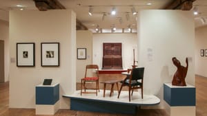 Various Esherick works, including sculpture, furniture, and prints, in a bright white-walled gallery with wooden floor.
