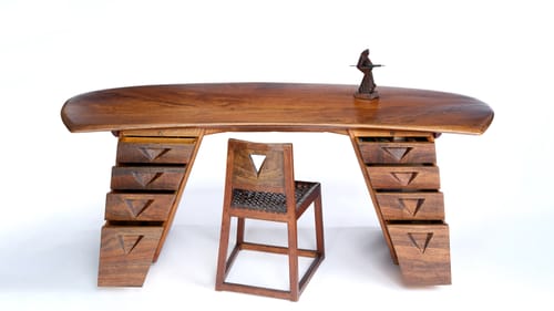Wooden desk with an inviting wide, smooth top and two columns of 4 drawers each underneath, making a trapezoid shape