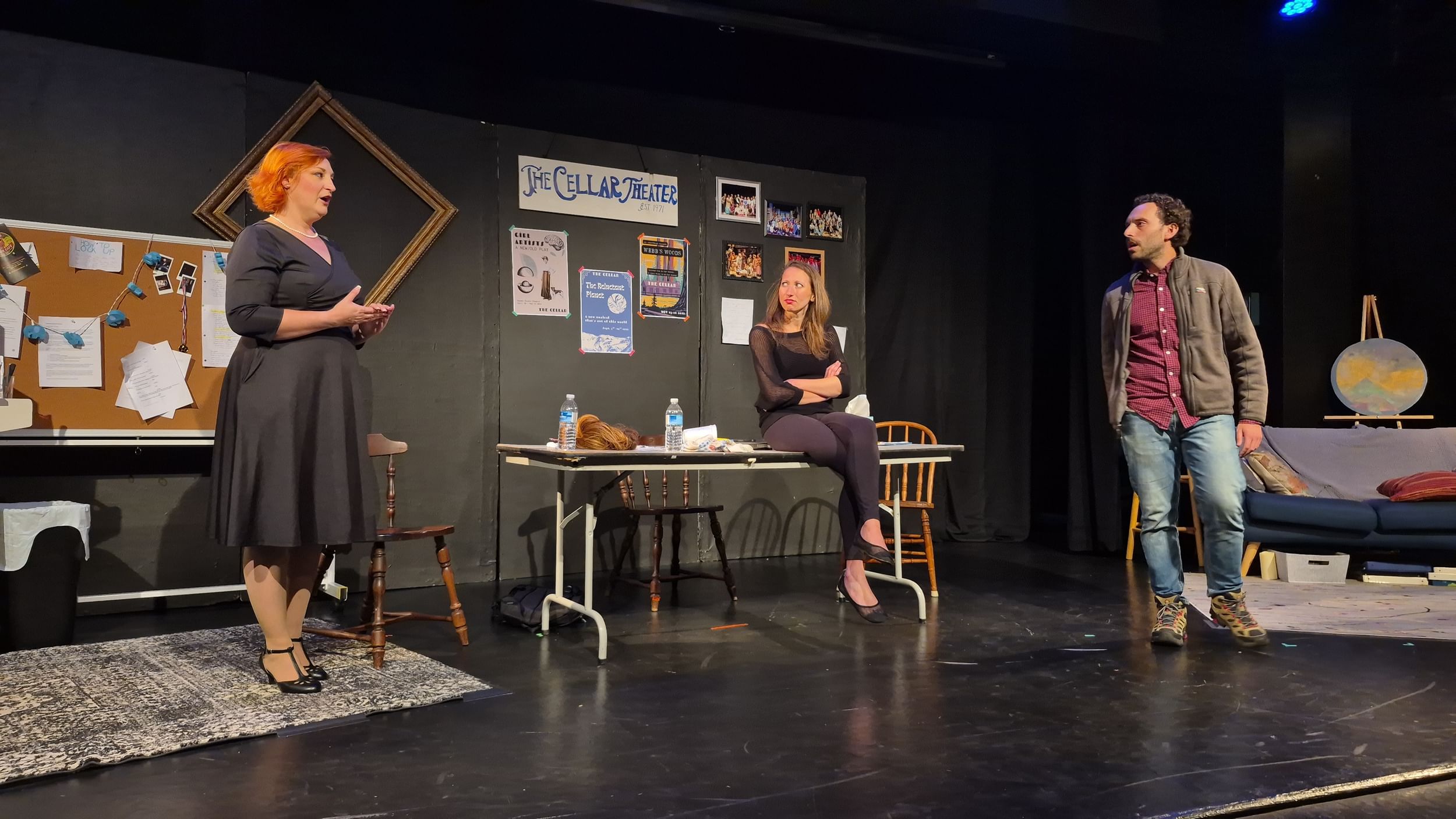 The actors have a heated discussion on a stage dressed to look like the greenroom at a regional called The Cellar Theater