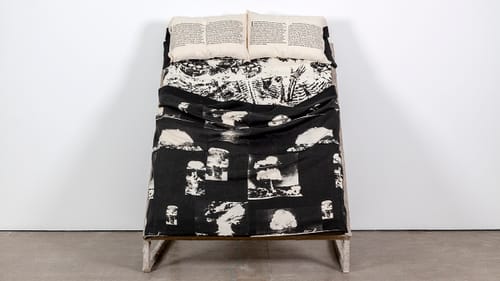 Gallery installation view of Restless Sleepers/Atomic Shroud, positioned like a bed propped up against the wall.