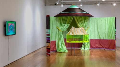 Gallery installation of Cardoso Flea Circus, including a section of green circus tent & mini-circus encased in green plastic