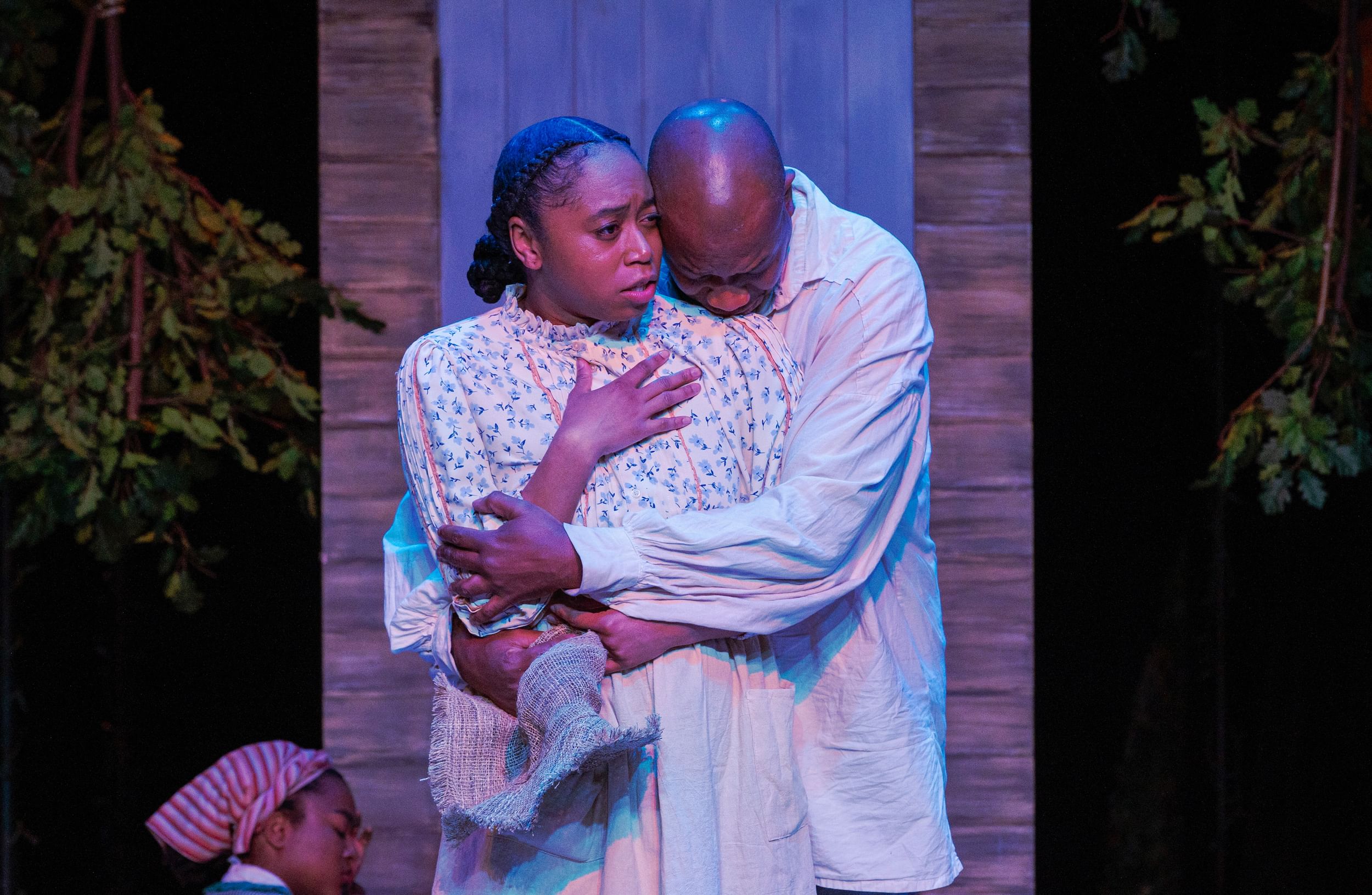 Anderson-Ross, in a floral blouse, puts a hand on her chest. Carter, behind, weeps on her shoulder, wrapping arms around her