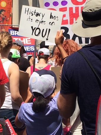 An 11-year-old protester holds a sign quoting the musical 'Hamilton.' (Photo by Anndee Hochman.)