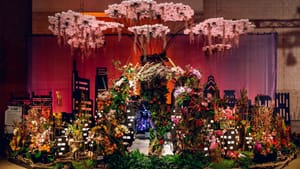 Large display with a riot of flower bouquets against a backdrop of the Philly skyline, with moss hanging from stylized clouds