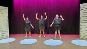 The 3 actors, in black and purple tennis outfits, pose in a line, each making a different gesture with their arms.