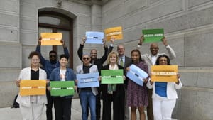 A multiracial group of 10 GPCA advocates hold signs supporting arts funding outside of Philly’s City Hall.