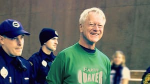 Book cover. Title in white & yellow over a photo of the elderly Lakey smiling broadly while 2 police lead him away handcuffed