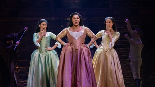 Mariasoosay and Soto look shocked as Harmon sings at center. They wear luxurious satin pastel-colored 18th-century dresses.