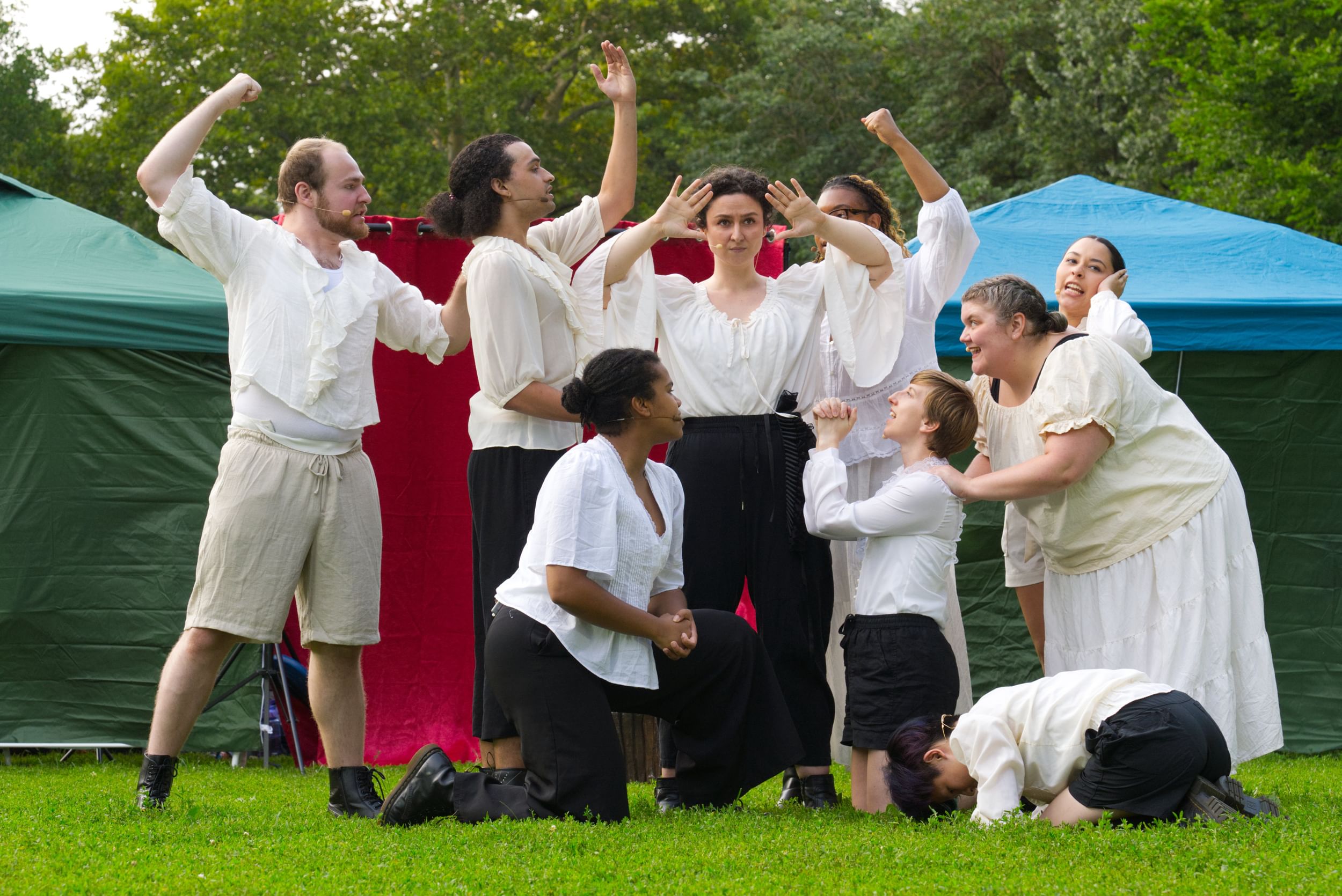 Pourshariati stands at center as the other 8 ensemble members, all in white shirts, crowd and gesture around her.