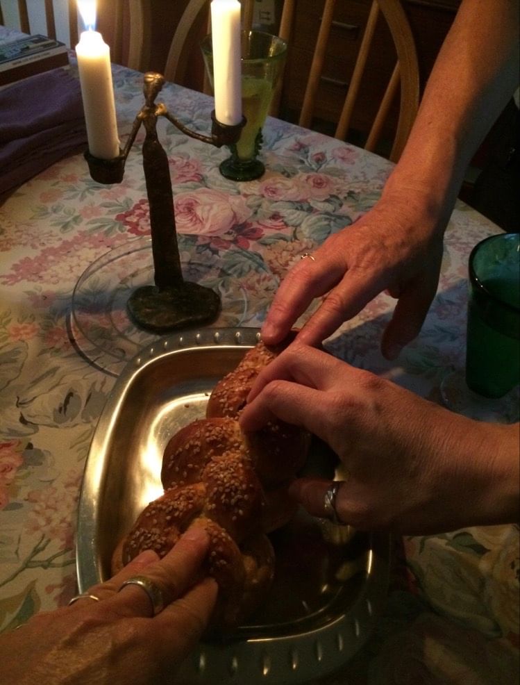 The author, her partner, and their housemate bless challah—made from a family recipe—on a recent Friday. (Image courtesy of the author.)