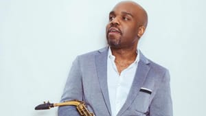 Shaw poses for a portrait-style photo, holding his saxophone.