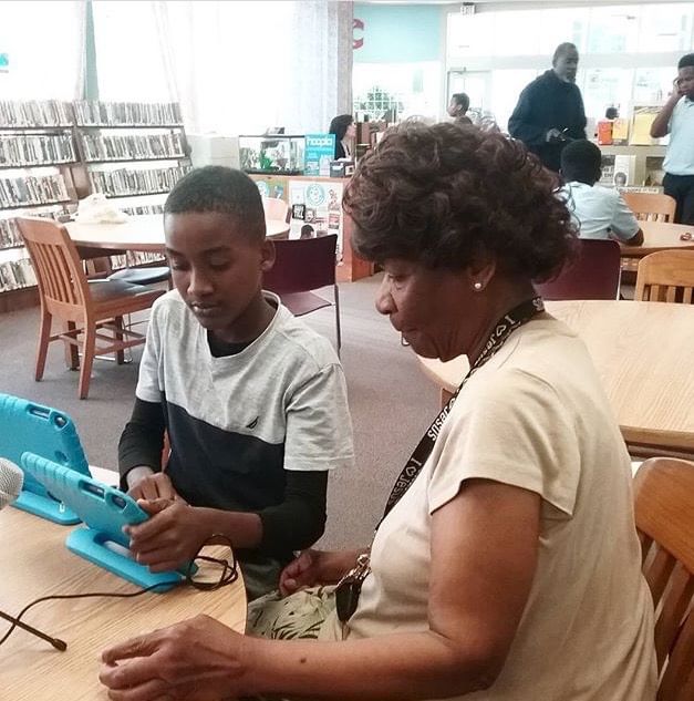 In West Oak Lane, a young PhillyCAM participant helps an older one learn to make a video. (Photo via People's Media Collection.)