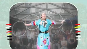 A woman in a turquoise dress with patterns with her arms out, five hoop rings linked from hand to hand behind her