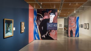 Gallery view of entrance, a large panel with an illustration of laughing people in glamorous 1920s costume party garb.