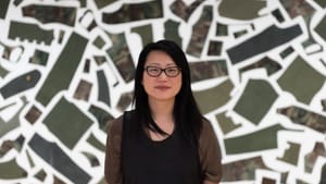 Shin stands before her installation "Armed," which is composed of veterans' castoff Army jackets. (Photo by Joseph Hu.)