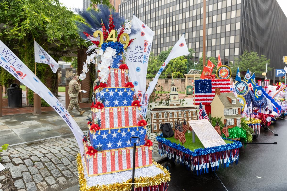 Lineup of sparkling colorful parade floats designed to look like Philly landmarks including Indy Hall & Betsy Ross House