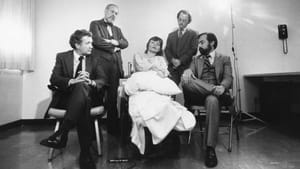 A black and white image of Bouvia in her wheelchair, pillow in lap, gazing ahead. Four male lawyers staged around her