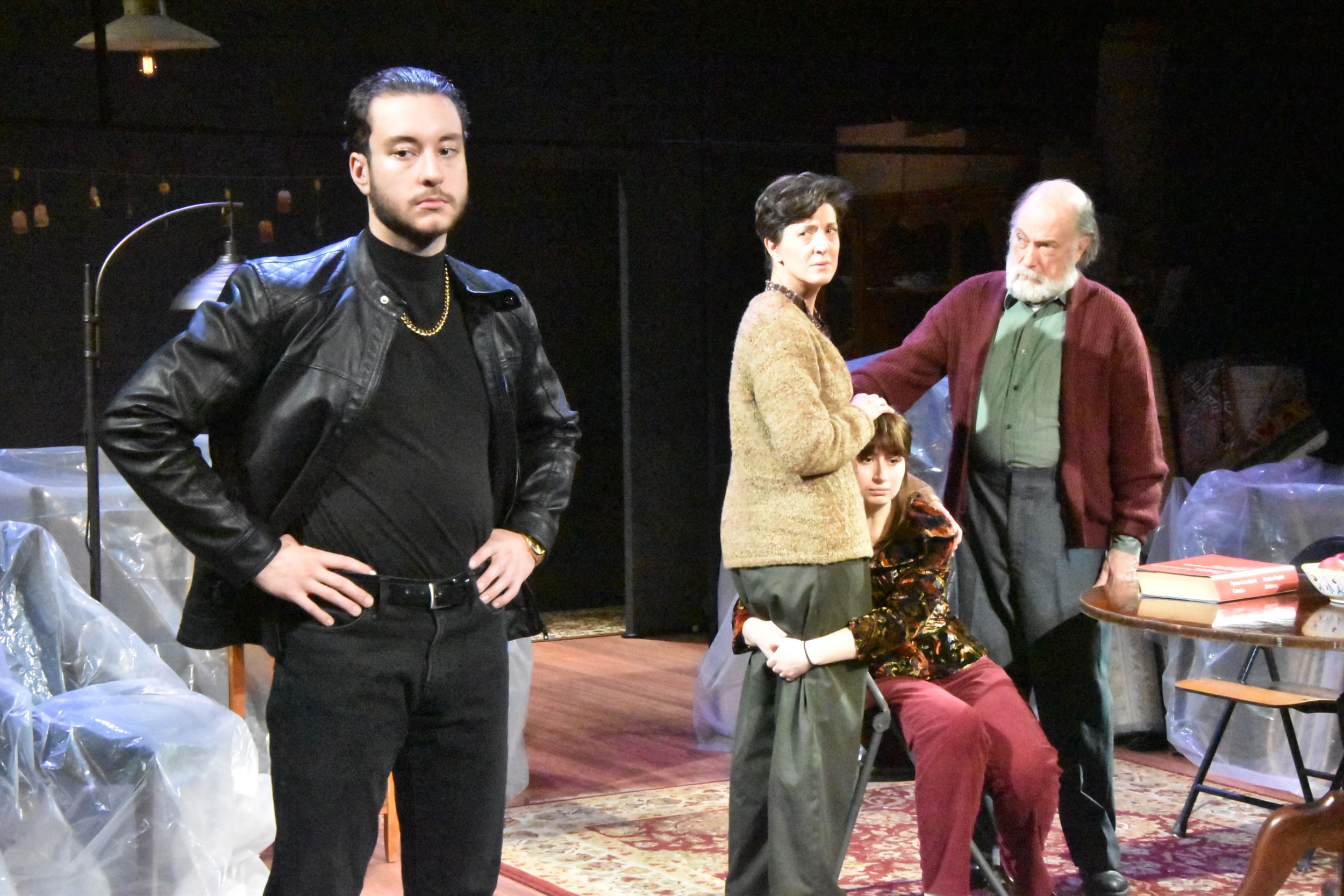 Howard, wearing black and frowning in the foreground. Walton, Weintzweig, & Moyer comfort each other sadly in the background.