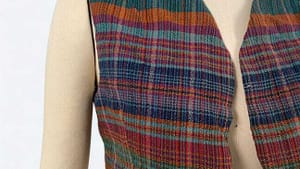 A cropped, gracefully shaped plaid vest in a surprising mix of green, orange, blue, and magenta shades.