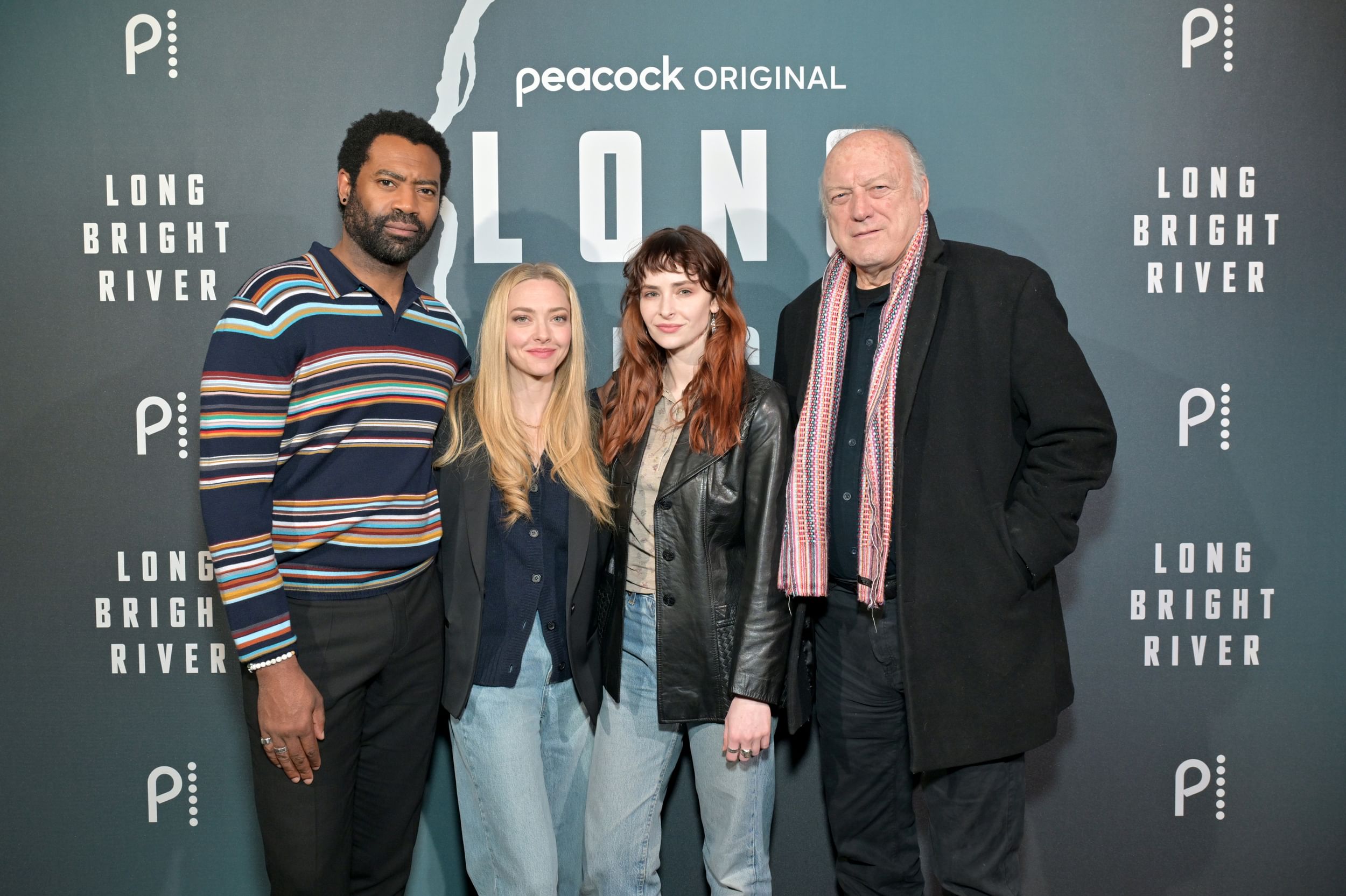 The four actors, in casual but stylish clothes, pose together next to a red-carpet backdrop with the Long Bright River logo.